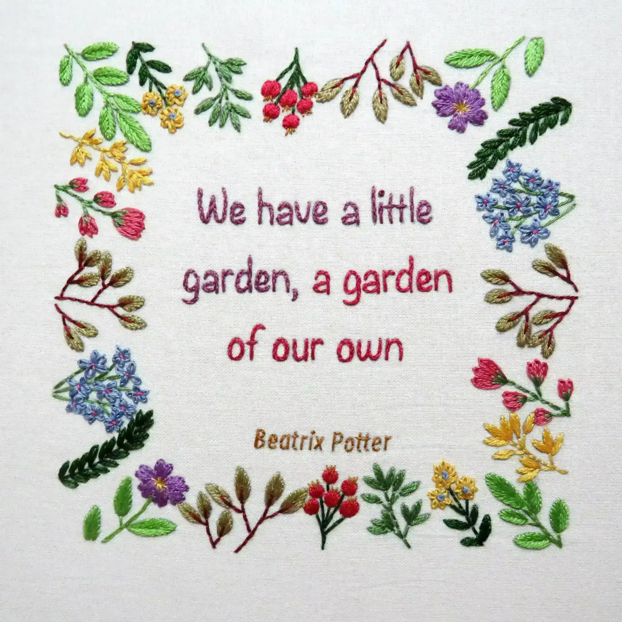 Embroidered quote with floral border on a white background