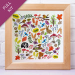Framed embroidery kit with colorful forest-themed design on a white background