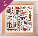 Embroidery kit with various animals and nature-themed designs in a wooden frame.