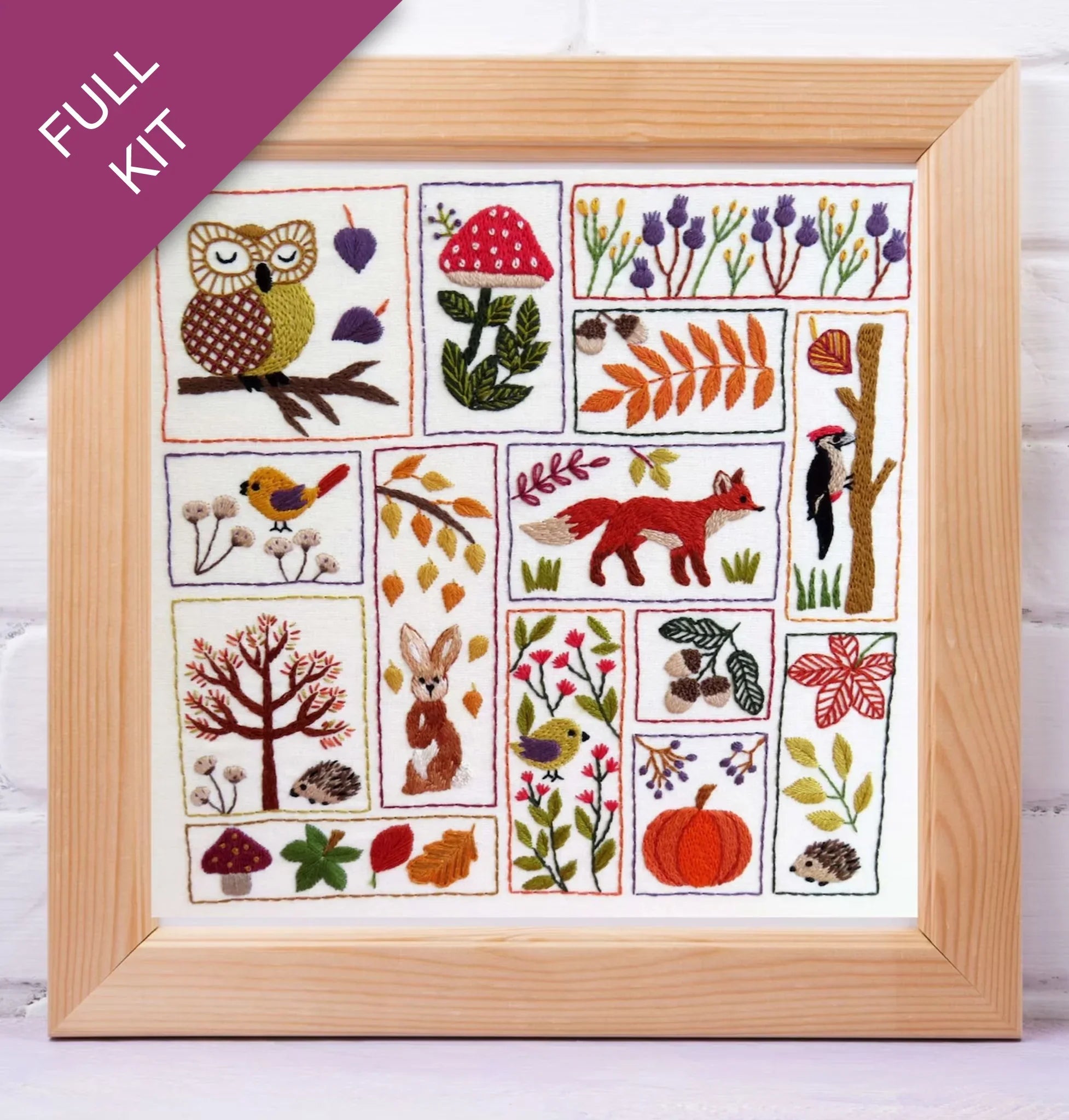Embroidery kit with various animals and nature-themed designs in a wooden frame.