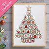 Framed cross-stitch pattern in the shape of a Christmas tree on a wooden surface with decorative items.