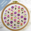 Embroidery hoop with floral and bee pattern on a marble surface