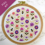 Embroidery hoop with floral and bee pattern on a white background