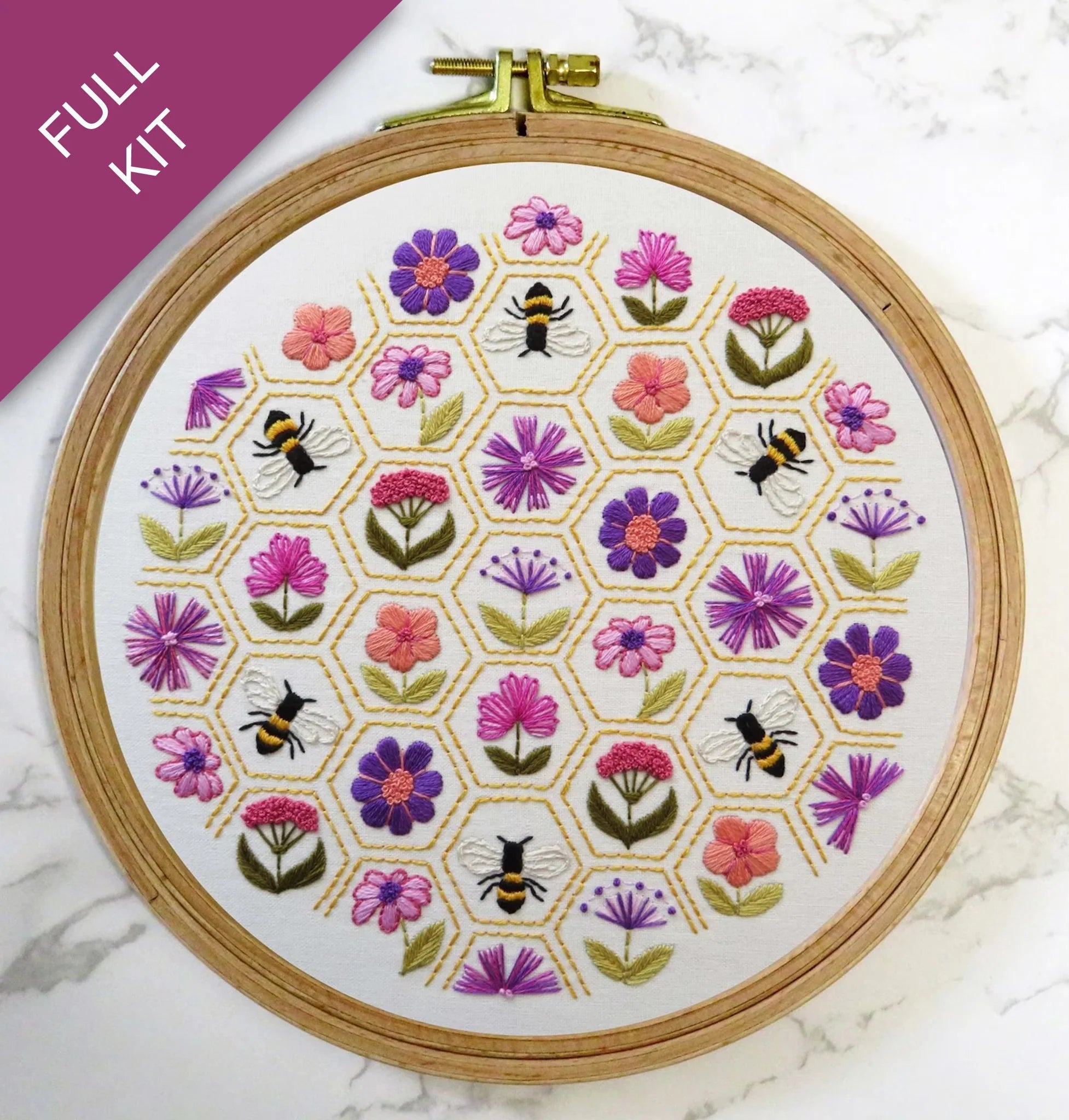 Embroidery hoop with floral and bee pattern on a white background
