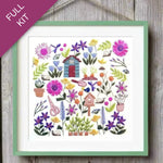 Embroidery kit with colorful flowers and birdhouses on a wooden surface