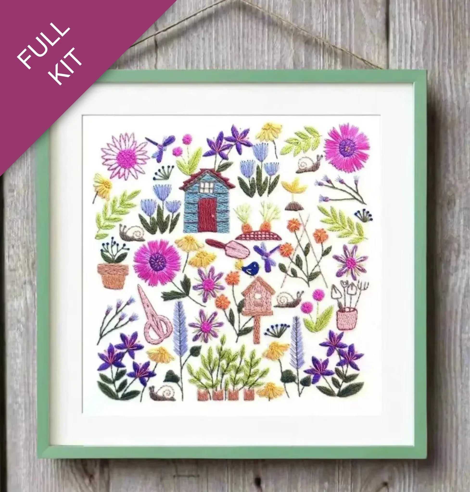 Embroidery kit with colorful flowers and birdhouses on a wooden surface