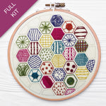 Embroidery hoop with colorful geometric patterns on a white background