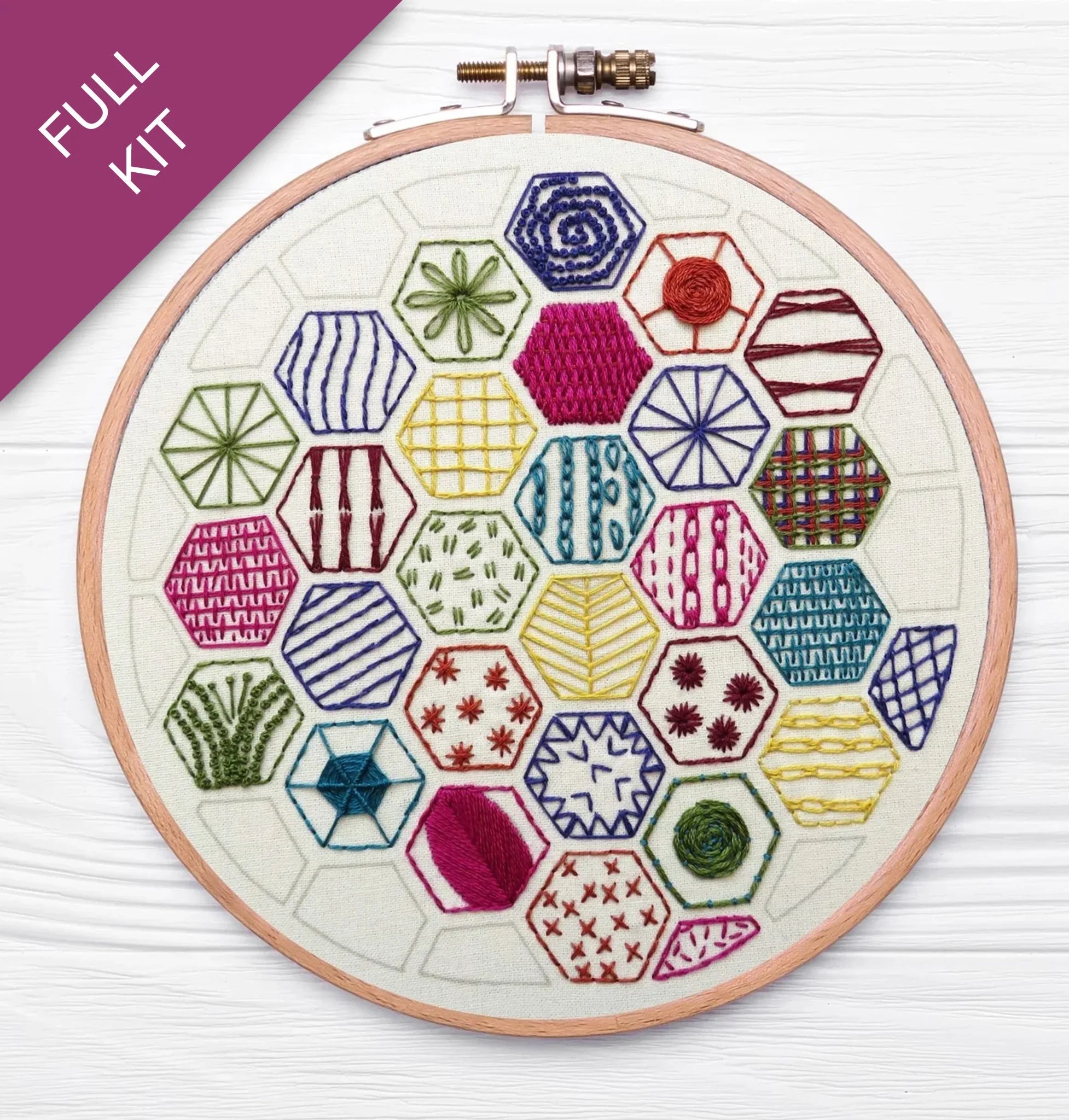 Embroidery hoop with colorful geometric patterns on a white background