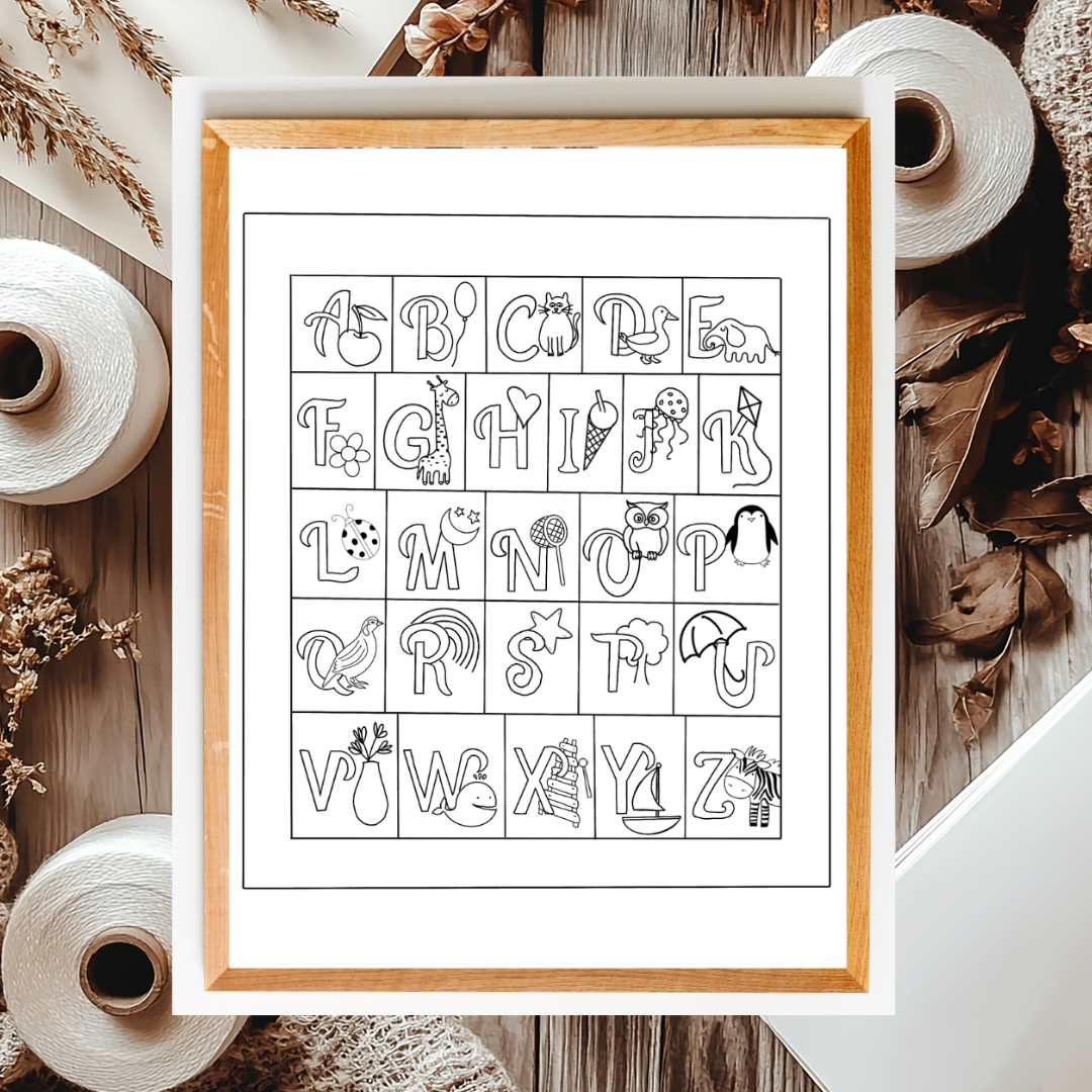 Framed alphabet poster with illustrations on a wooden surface