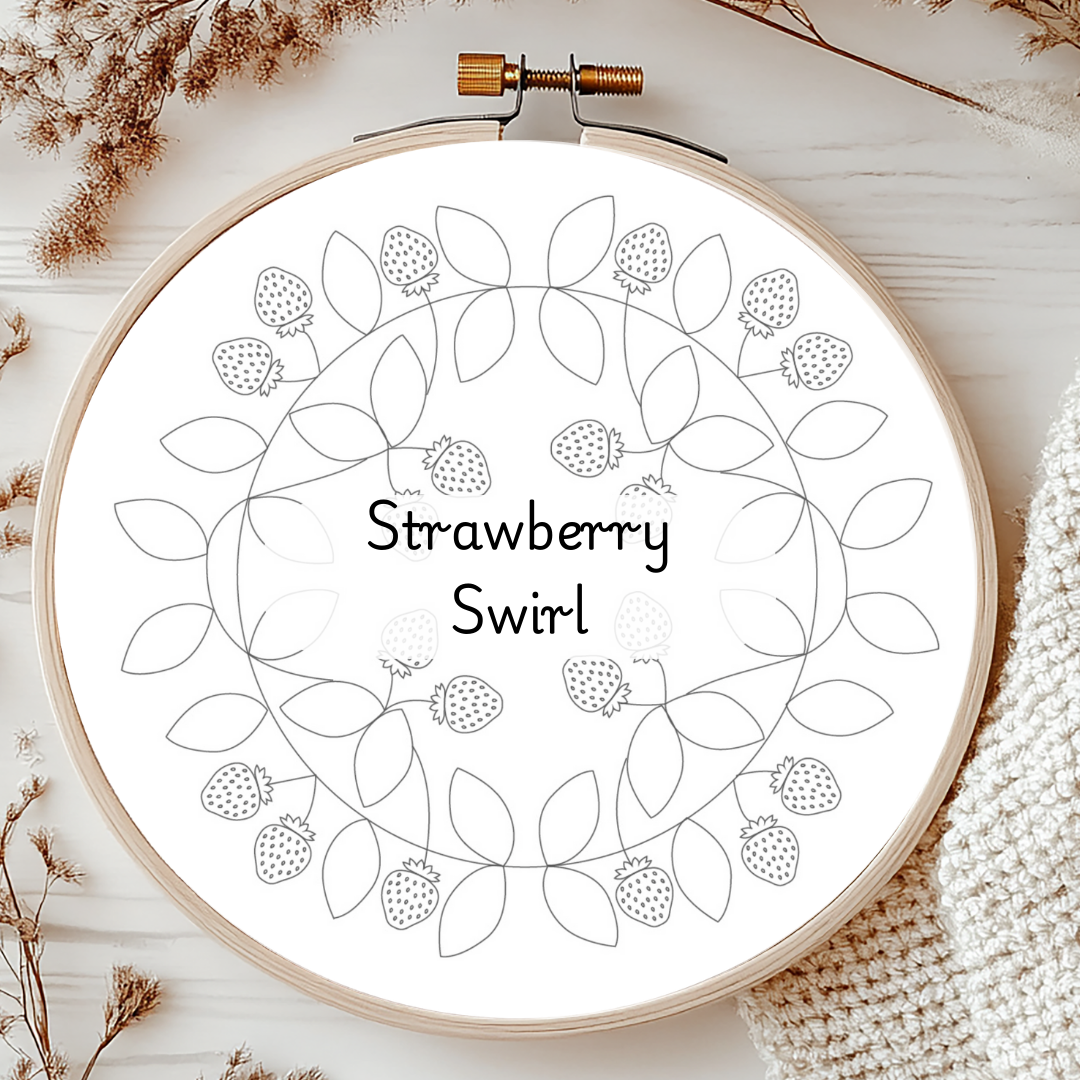 Embroidery hoop with 'Strawberry Swirl' design on a wooden surface.