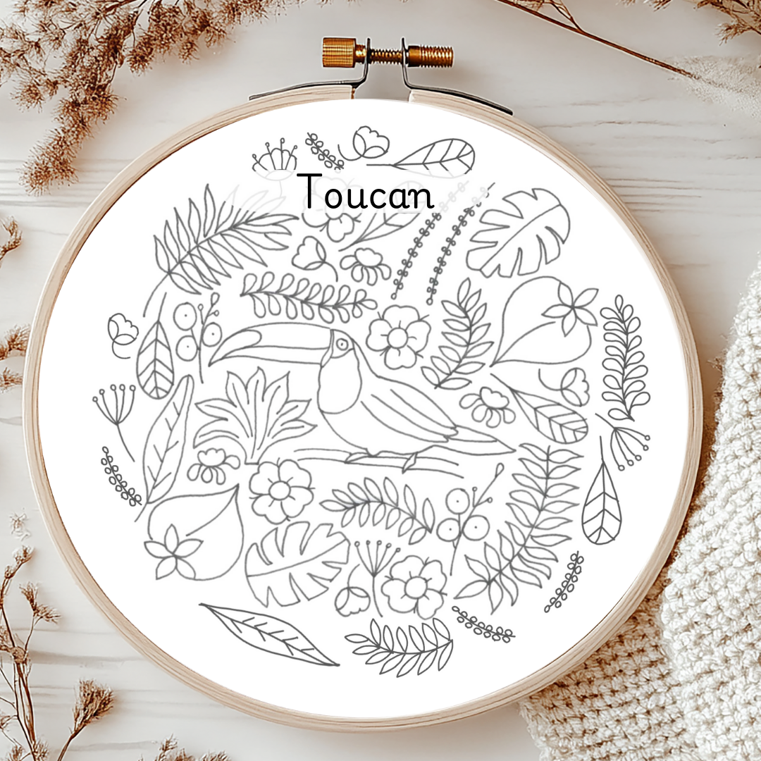 Embroidery hoop with a toucan and leaf design on a white background