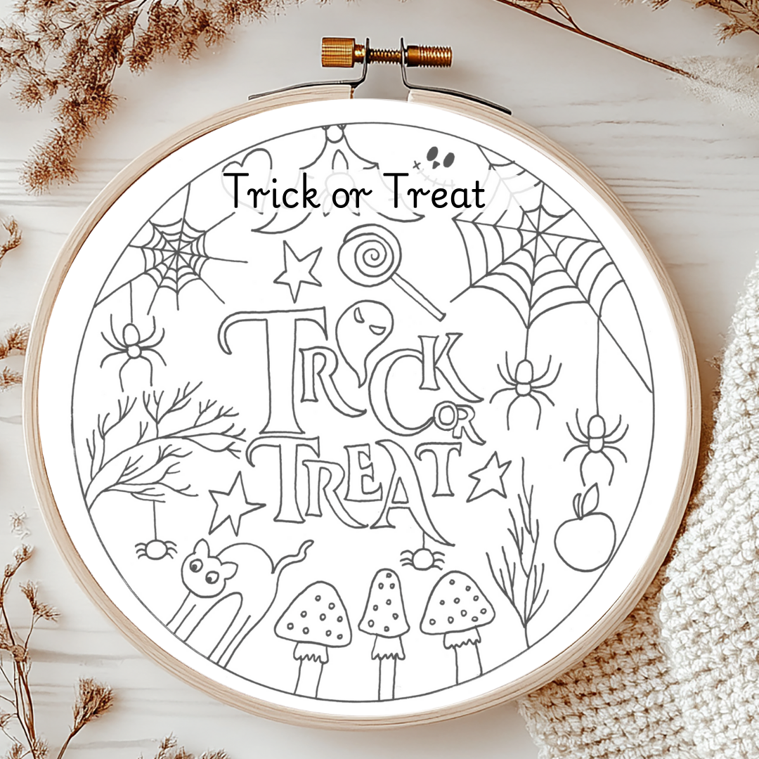 Halloween-themed coloring page in an embroidery hoop on a wooden surface with decorative elements.