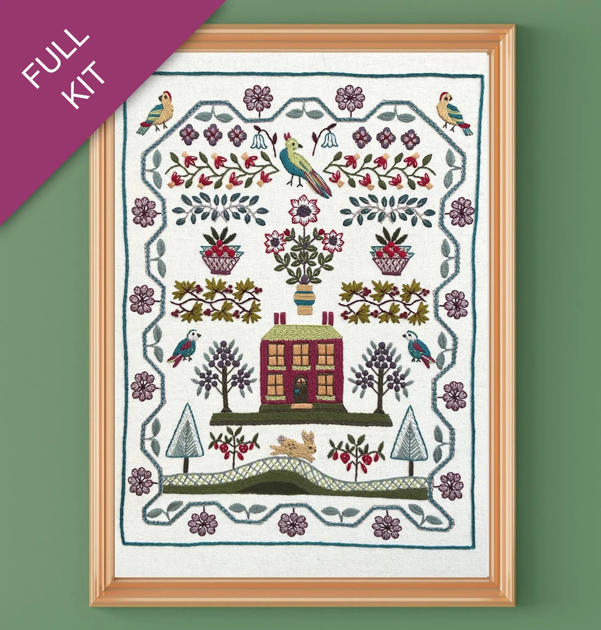 Embroidery kit with a house and nature design on a green background
