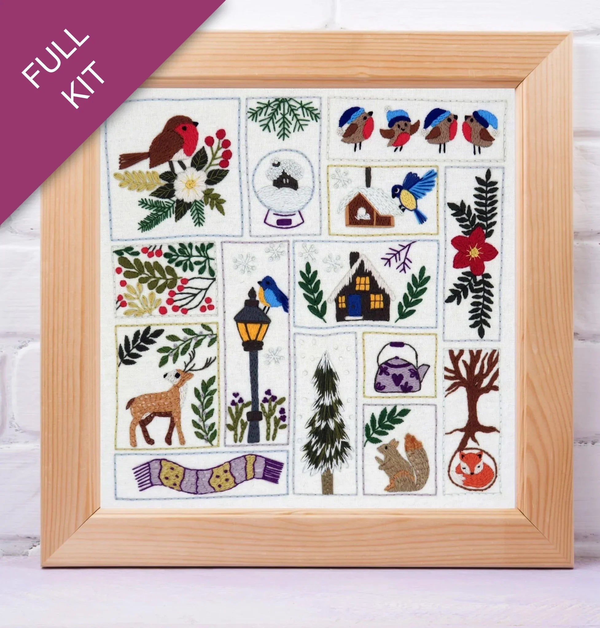 Framed cross-stitch kit with various designs including birds, flowers, and animals on a white background.