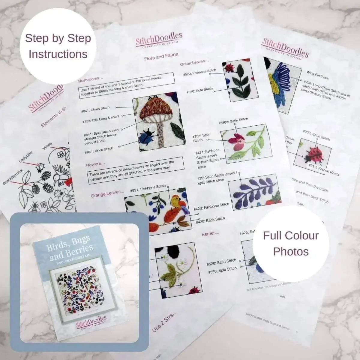 StitchDoodles embroidery pattern sheets with step-by-step instructions and full-color photos on a marble surface.
