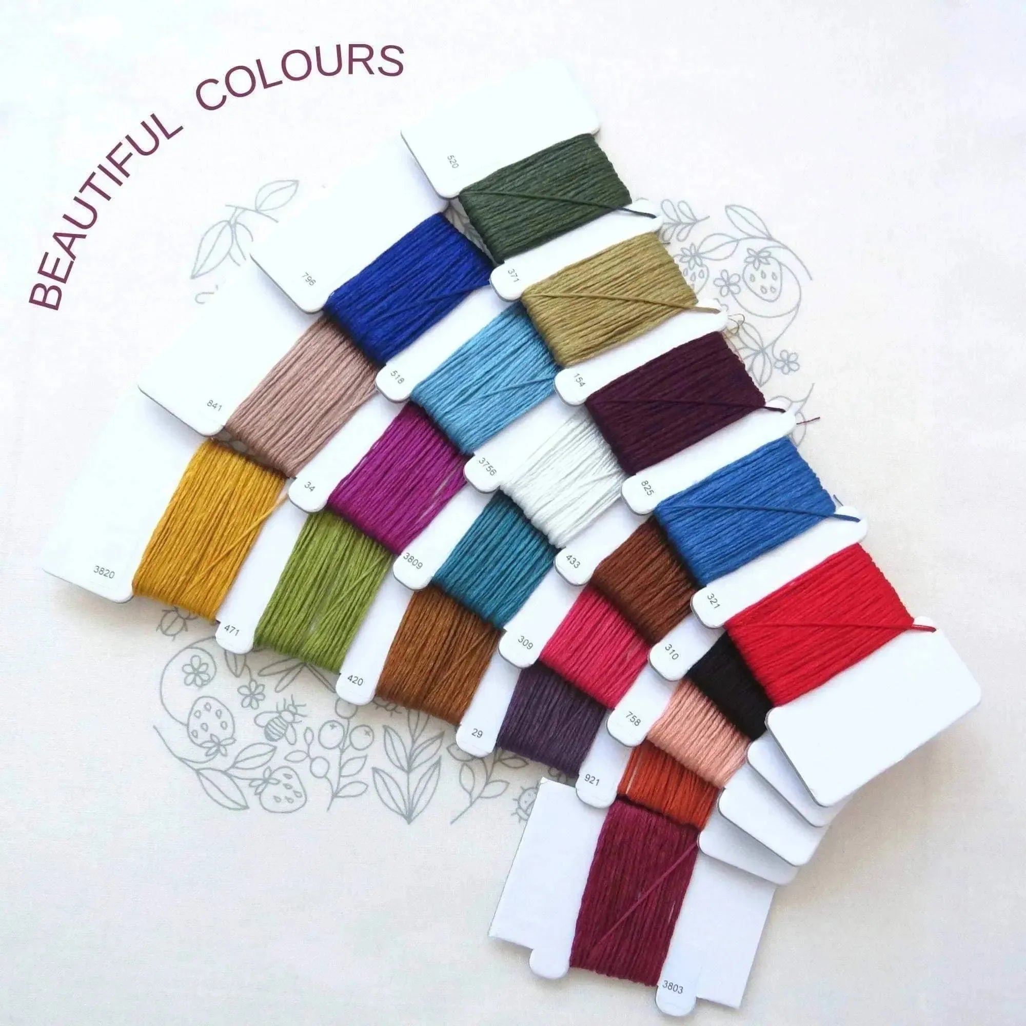 Set of colorful embroidery threads on a white background with 'BEAUTIFUL COLOURS' text.