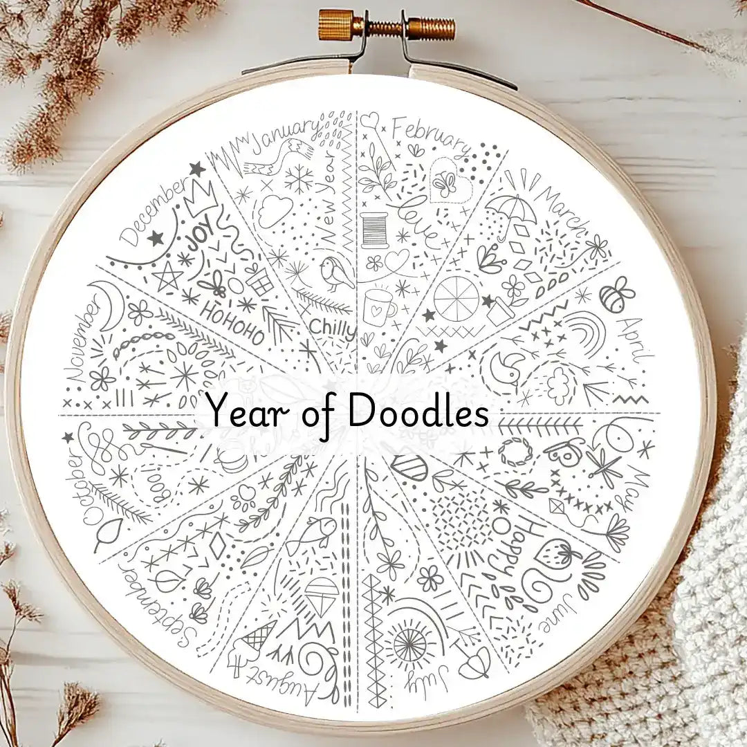 Circular design with 'Year of Doodles' text inside an embroidery hoop on a wooden surface.
