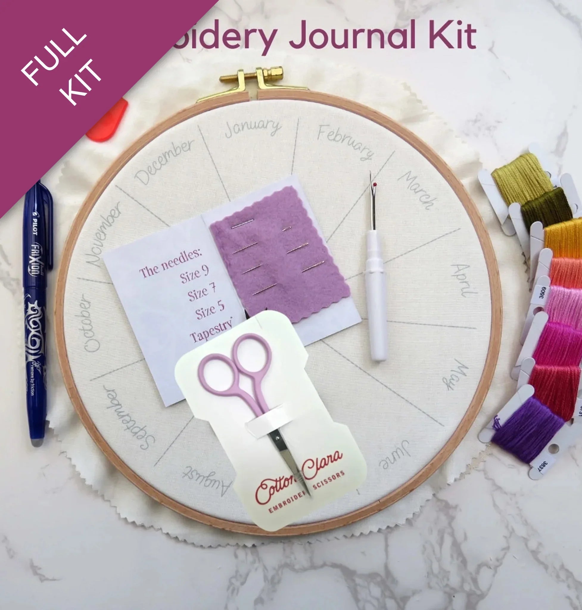 Embroidery kit with supplies including an embroidery hoop, scissors, and thread on a marble surface.