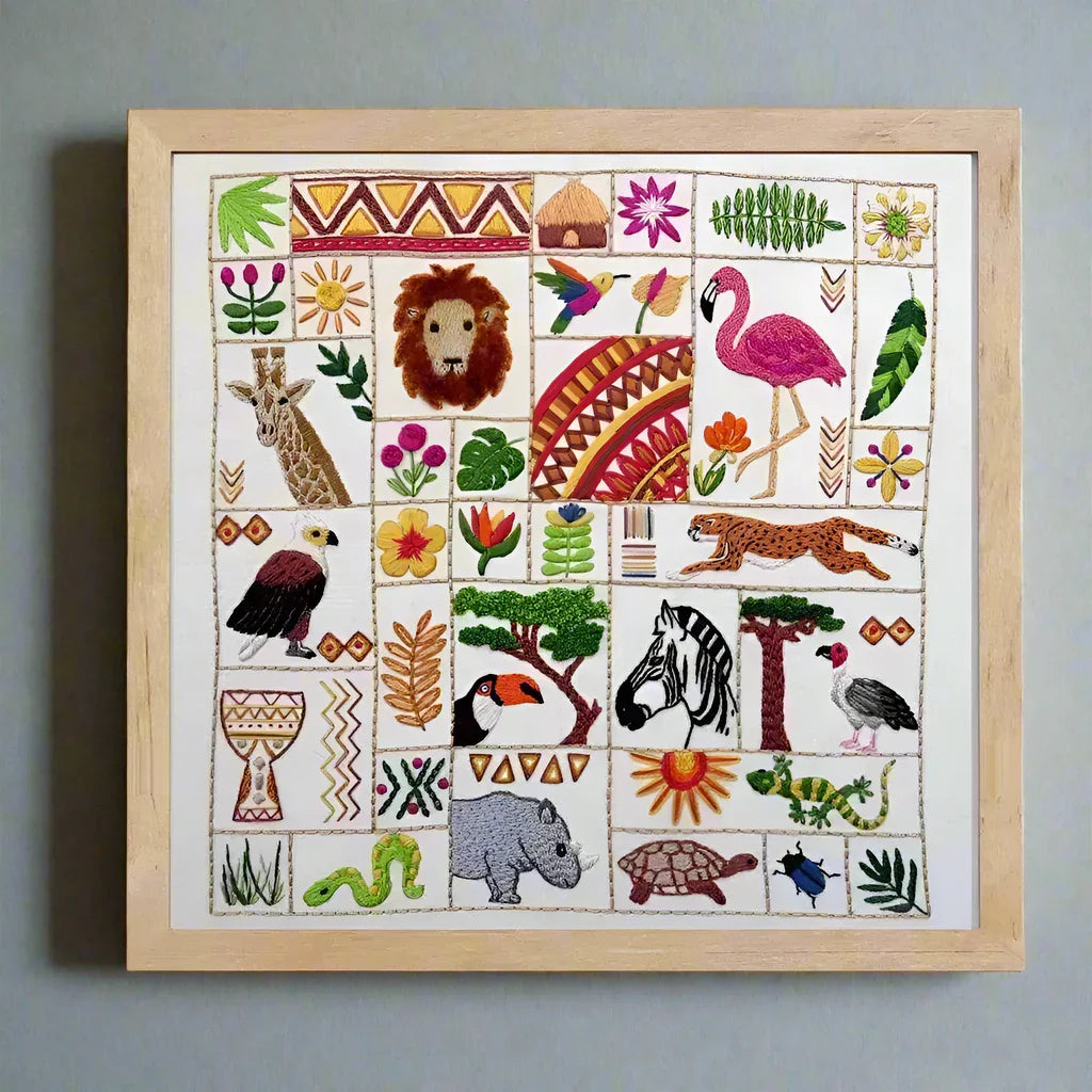 Framed embroidery with various animals and patterns on a light gray background