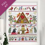 Embroidery kit with Christmas-themed design featuring a cabin, animals, and festive elements.