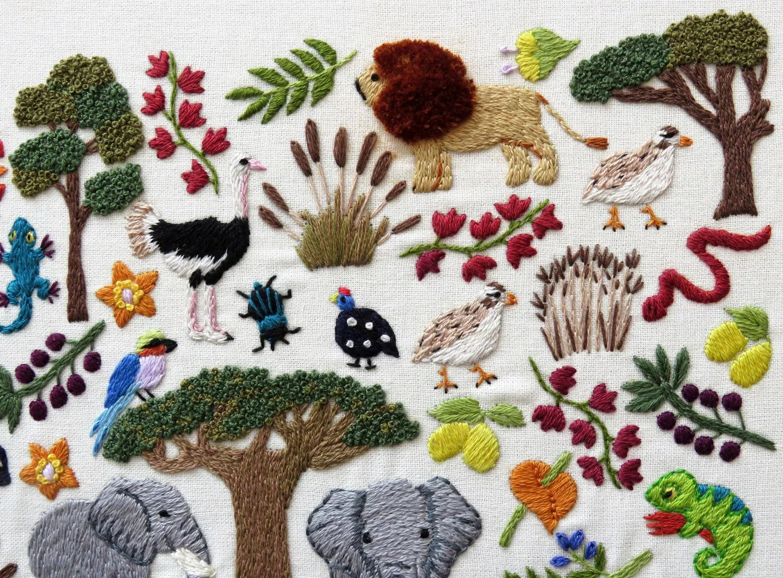 Embroidered design of animals and nature elements on a white background