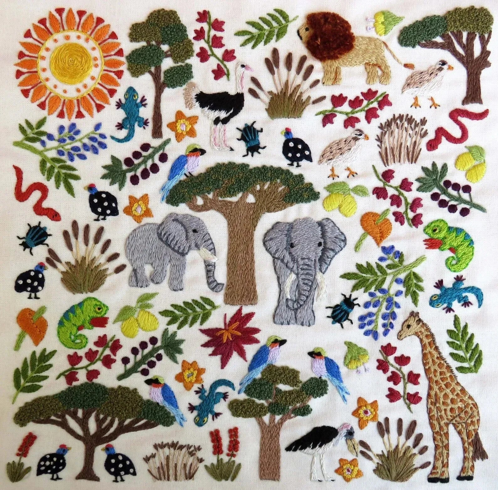 Embroidered pattern with animals, trees, and flowers on a white background
