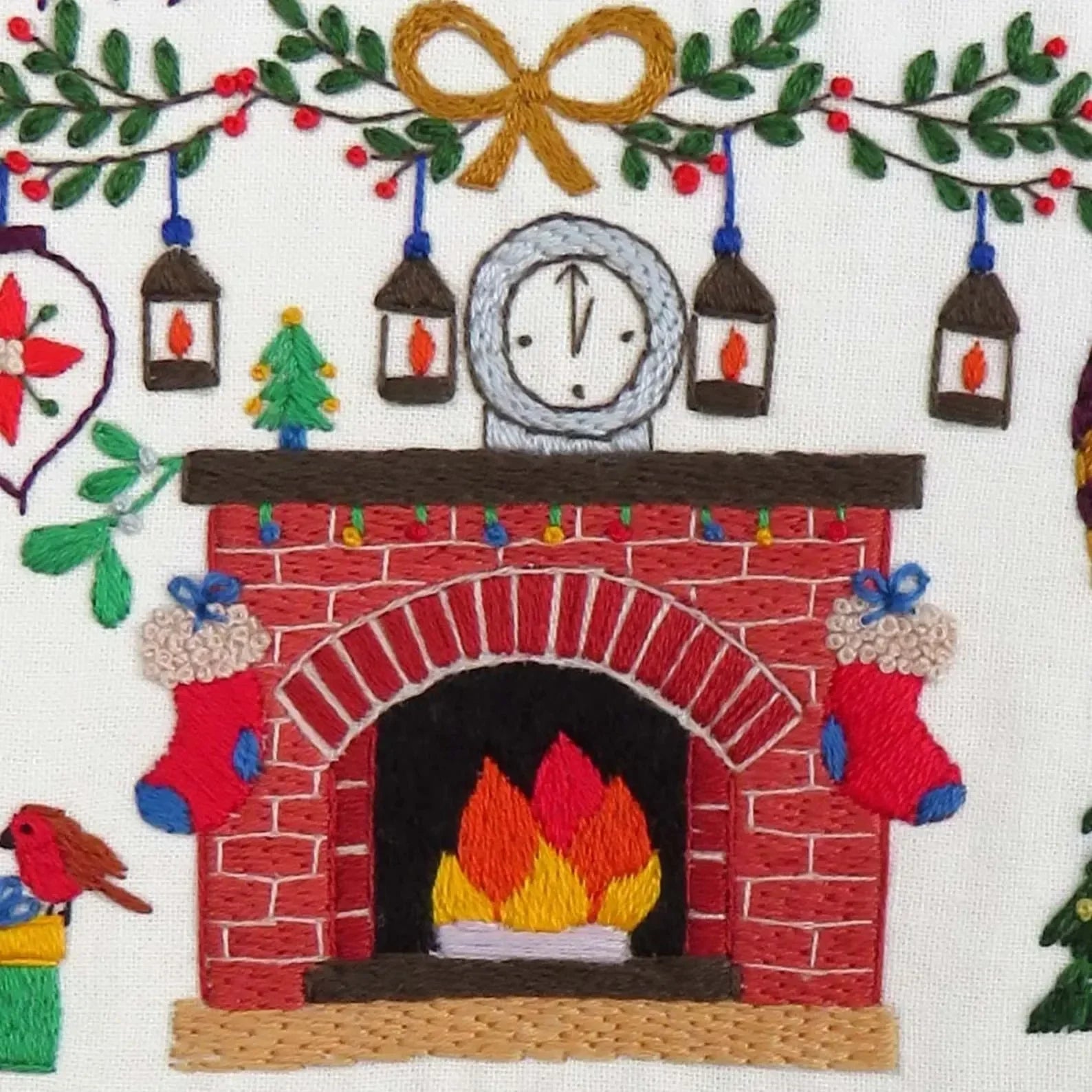 Embroidered design of a fireplace with festive decorations