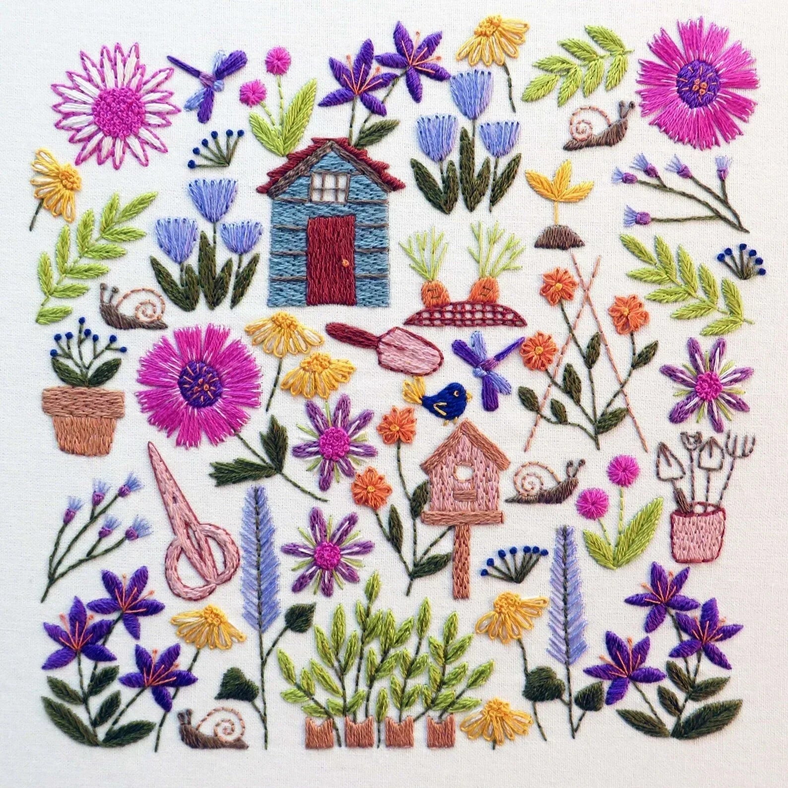 Embroidered design with flowers, plants, and small structures on a white background