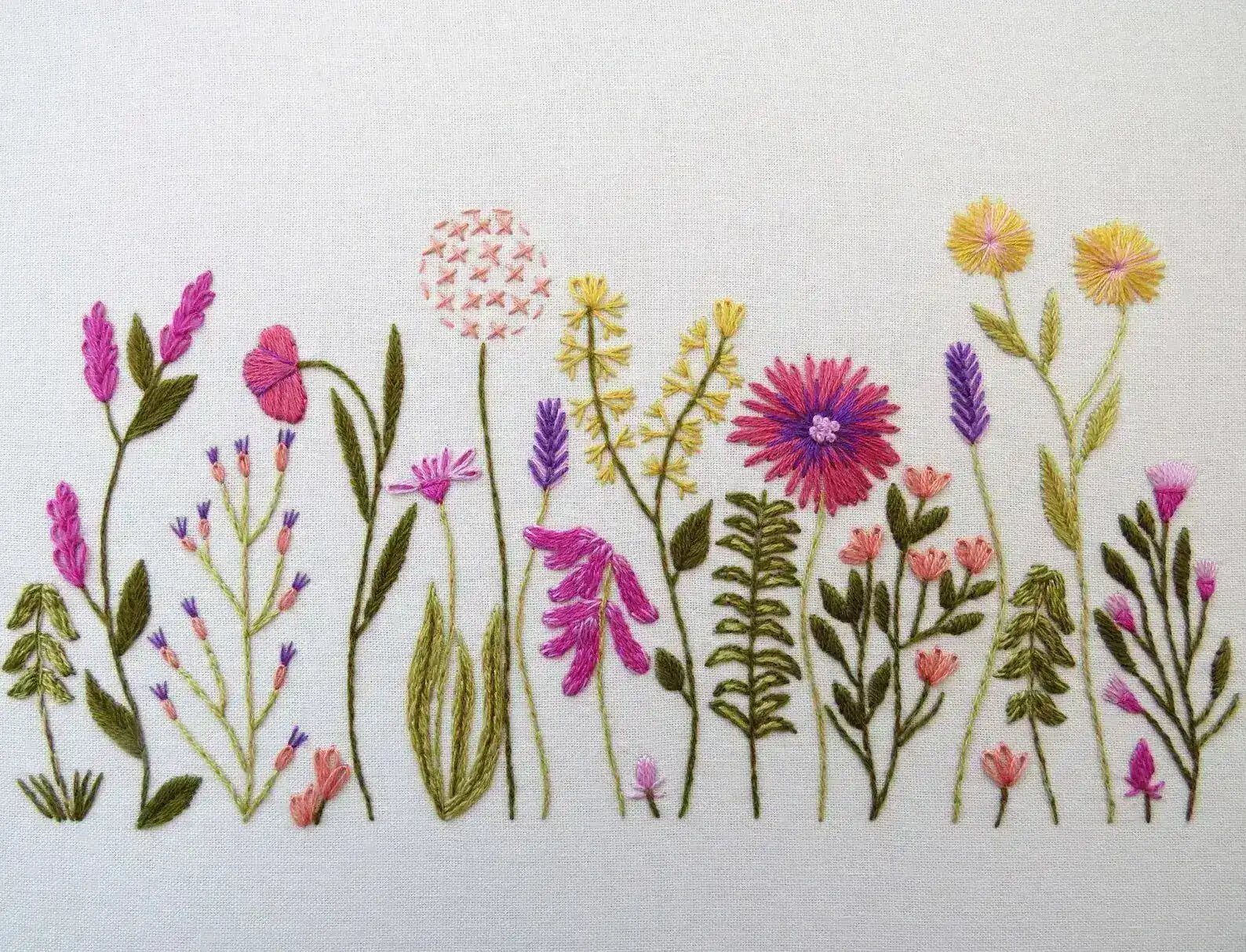 Embroidered design of various flowers on a white background