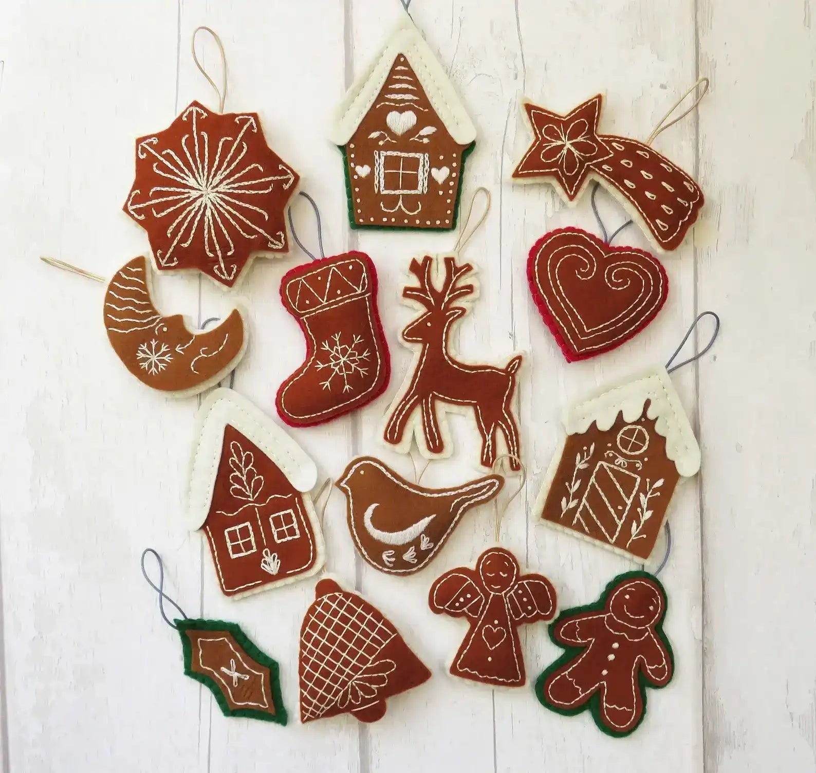 Set of Christmas-themed gingerbread cookie decorations on a white wooden background