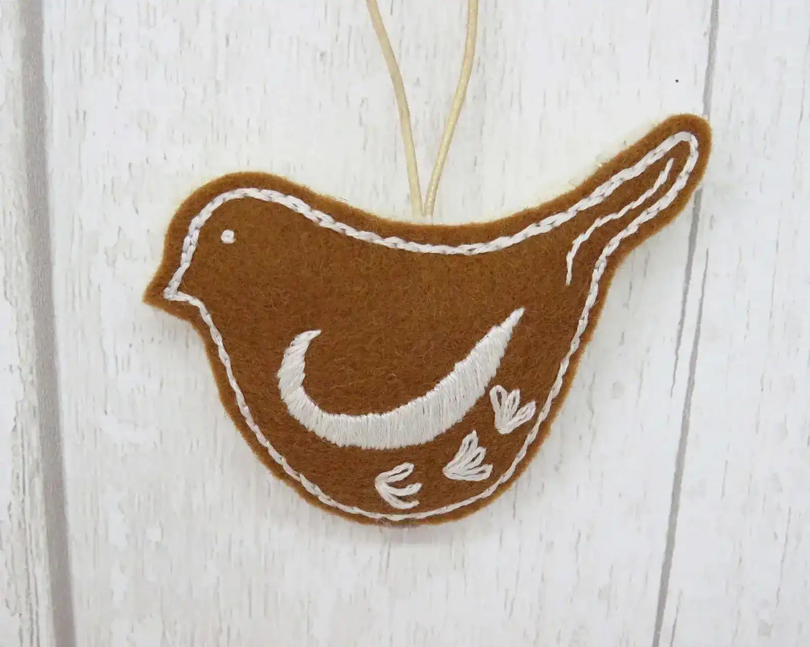 Brown and white bird-shaped ornament on a wooden surface