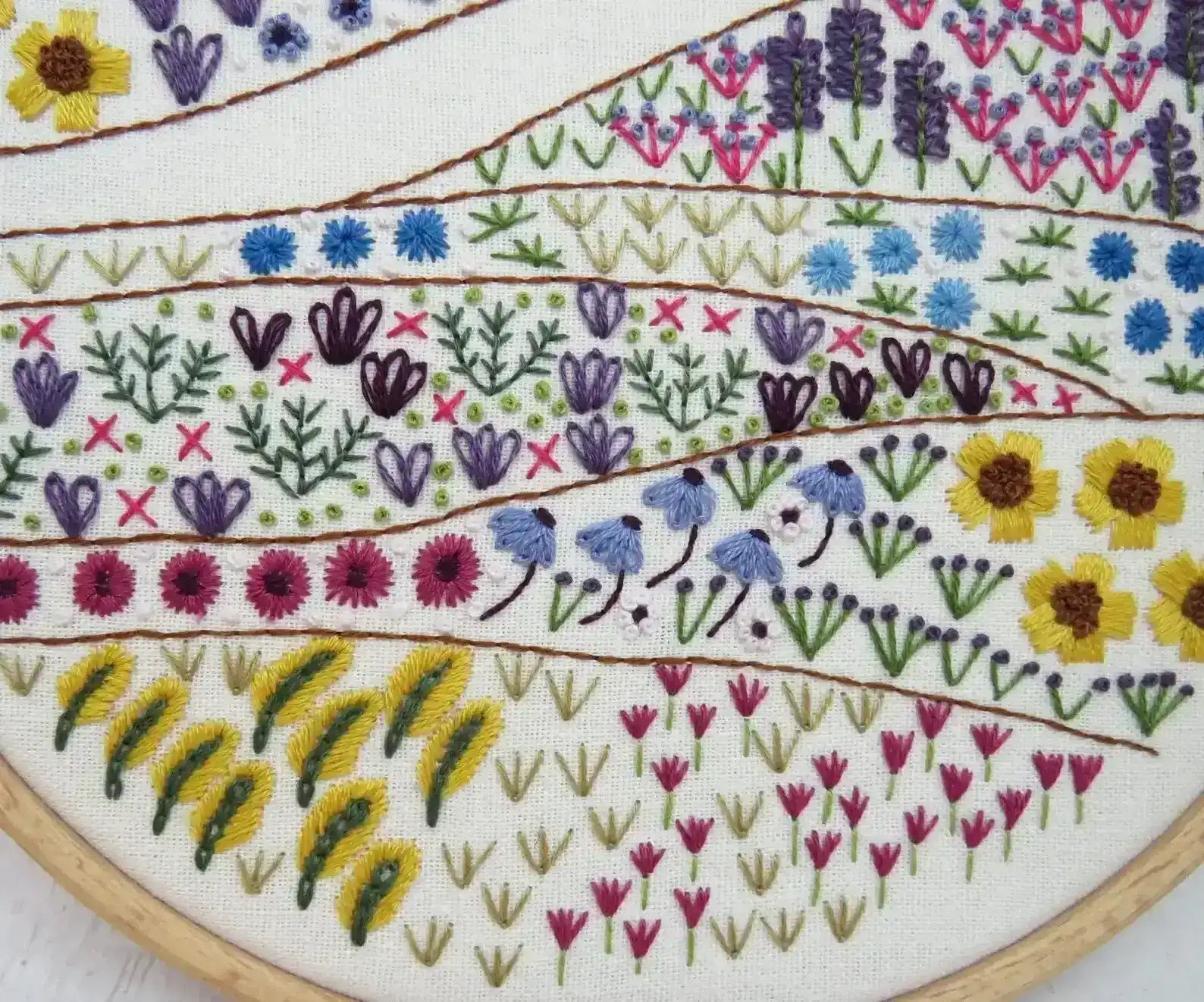 Embroidery hoop with floral and animal pattern on a white background