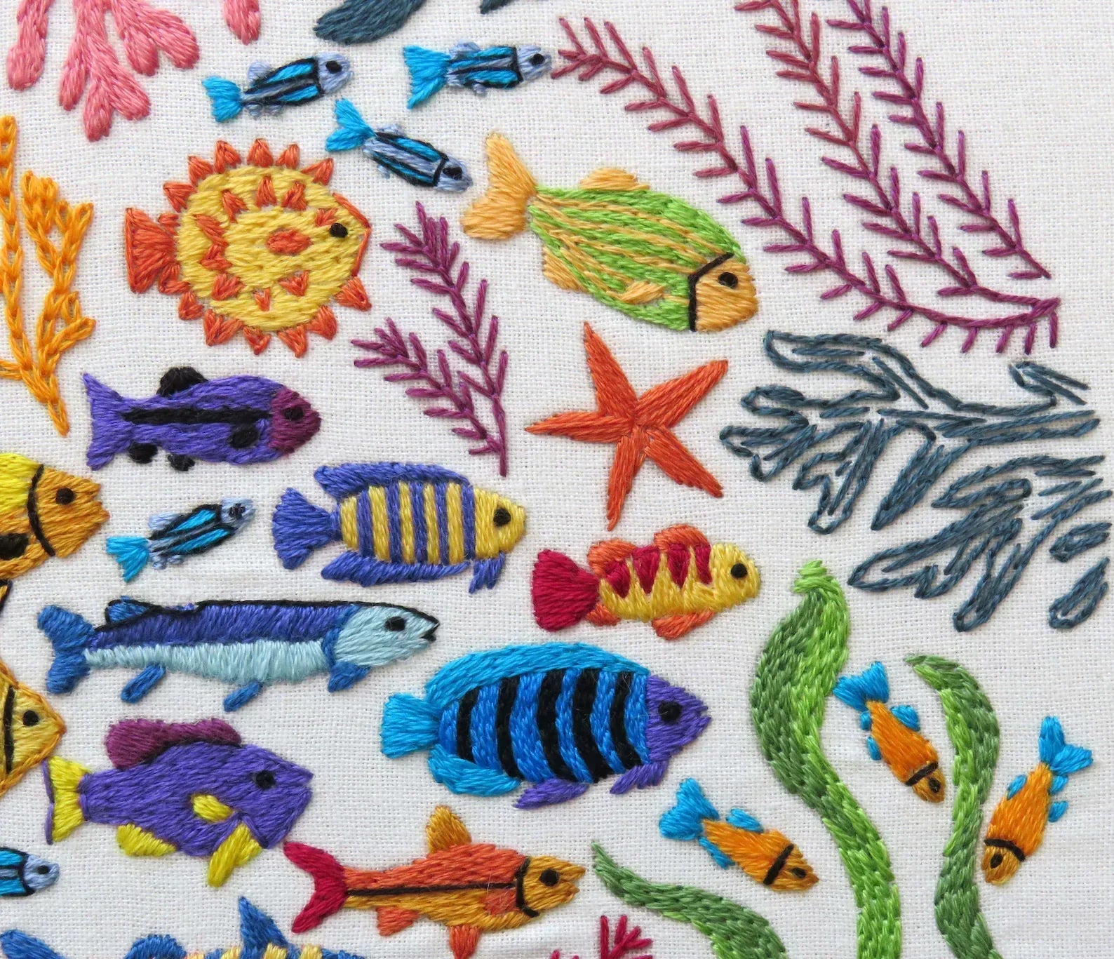 Embroidered pattern of colorful fish and sea plants on a white background