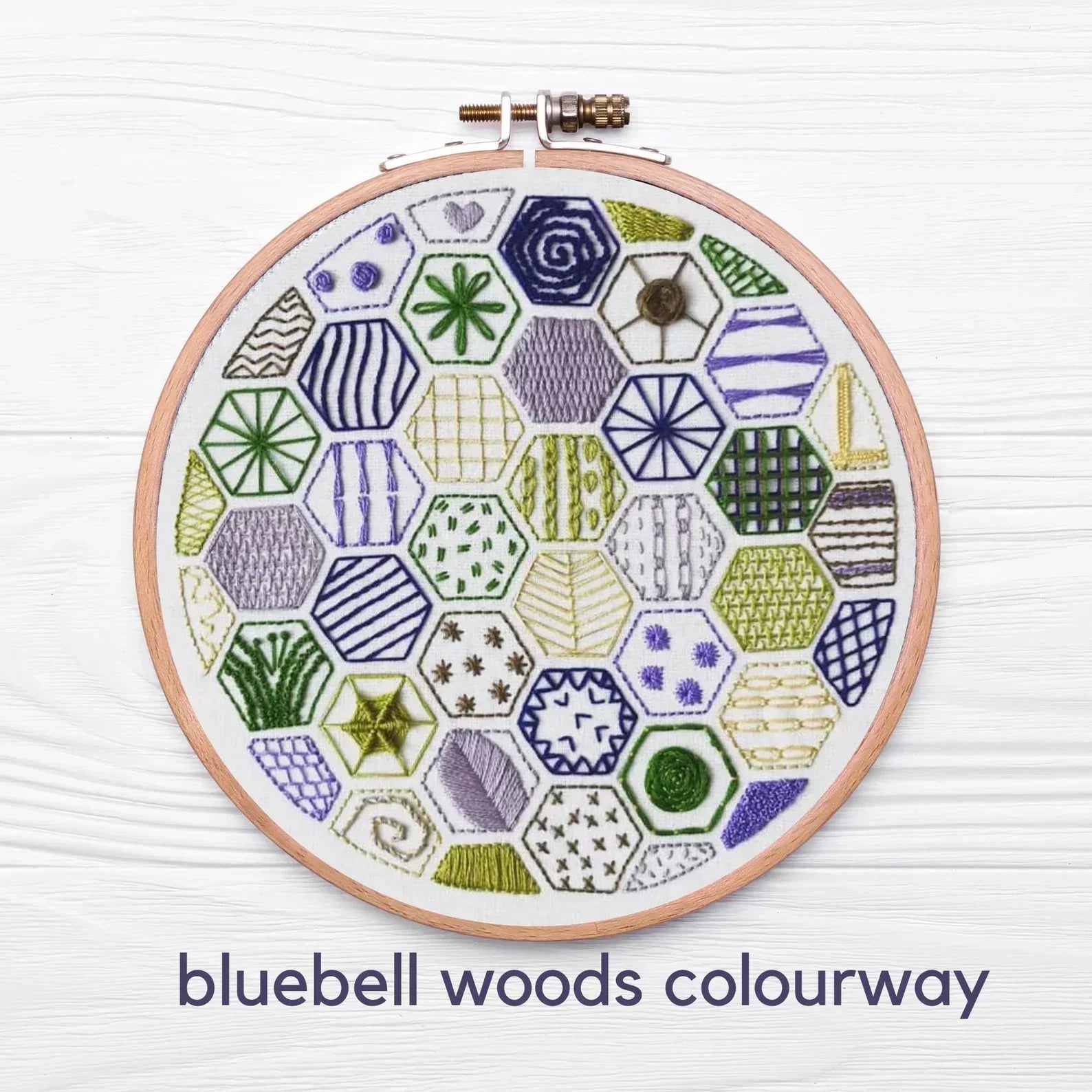 Embroidery hoop with geometric pattern on a white background, labeled 'bluebell woods colourway'.