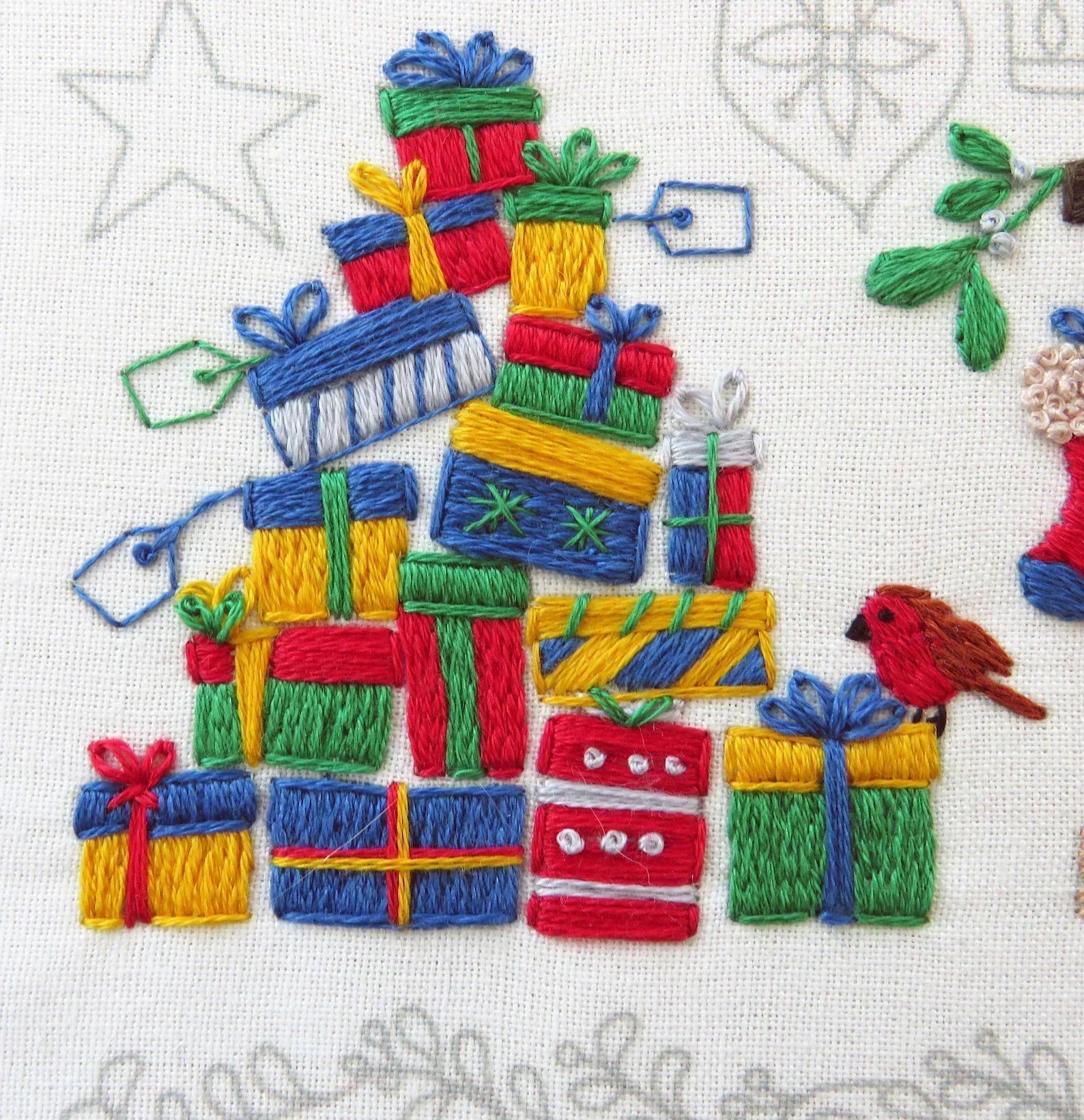 Embroidered design of colorful gift boxes arranged in a tree shape on a white background.