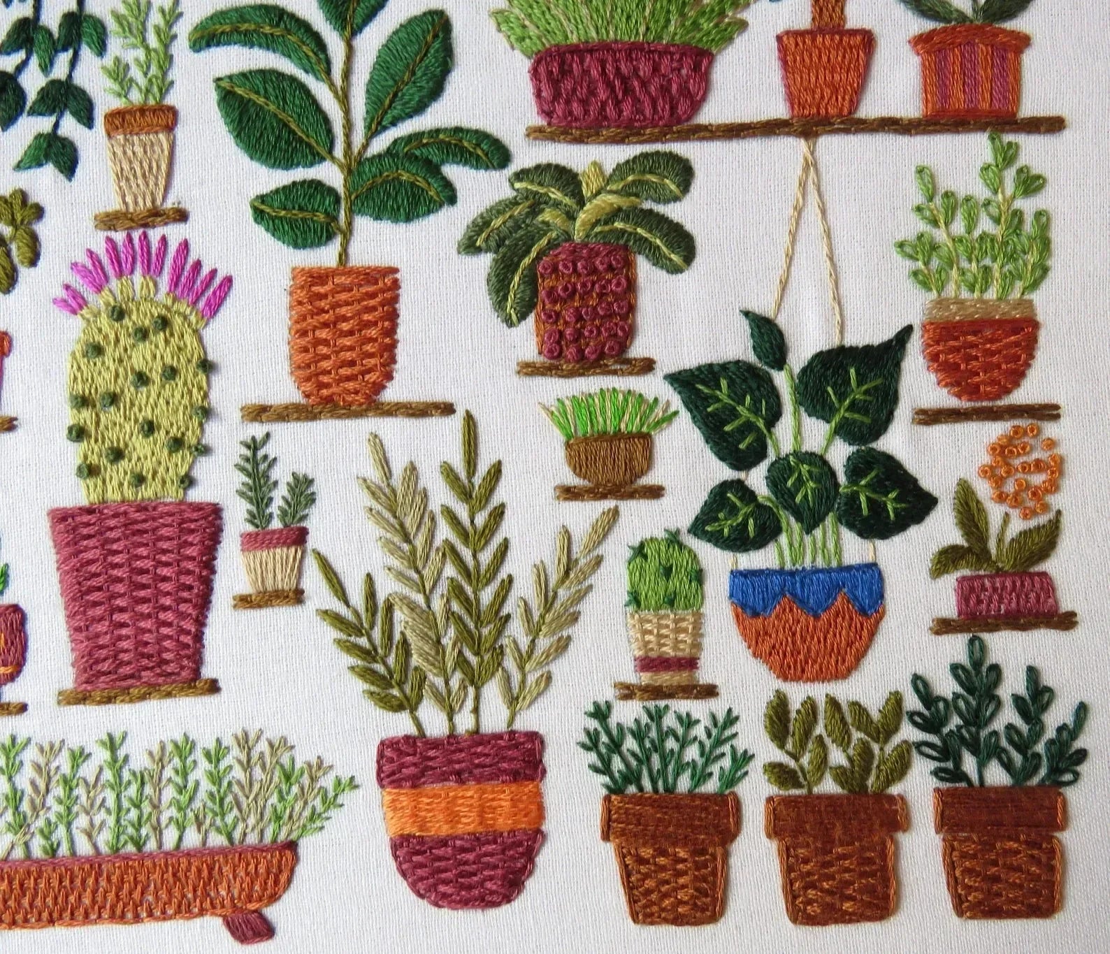 Embroidered pattern of various potted plants on a white background