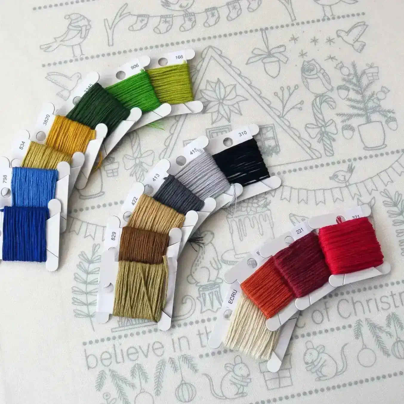 Set of colorful embroidery threads on a decorative paper background