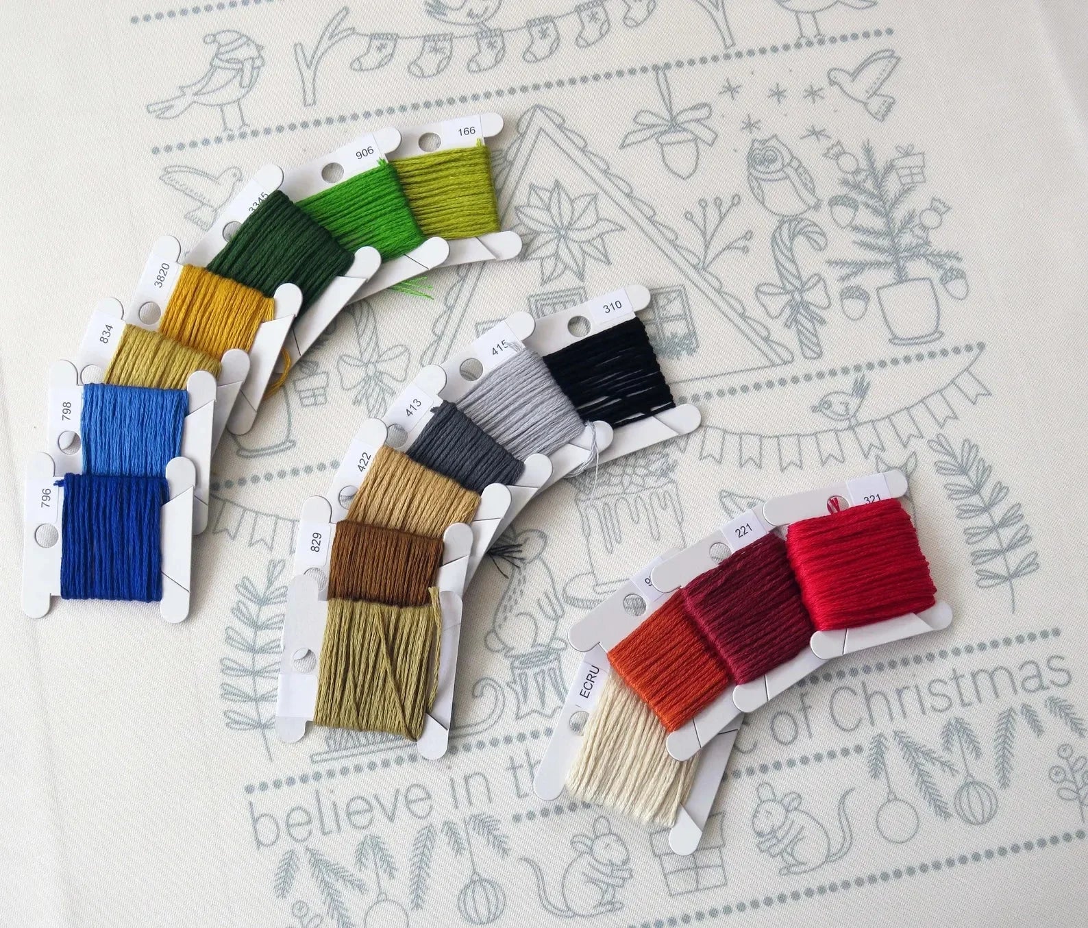 Set of colorful embroidery threads on a decorative paper background