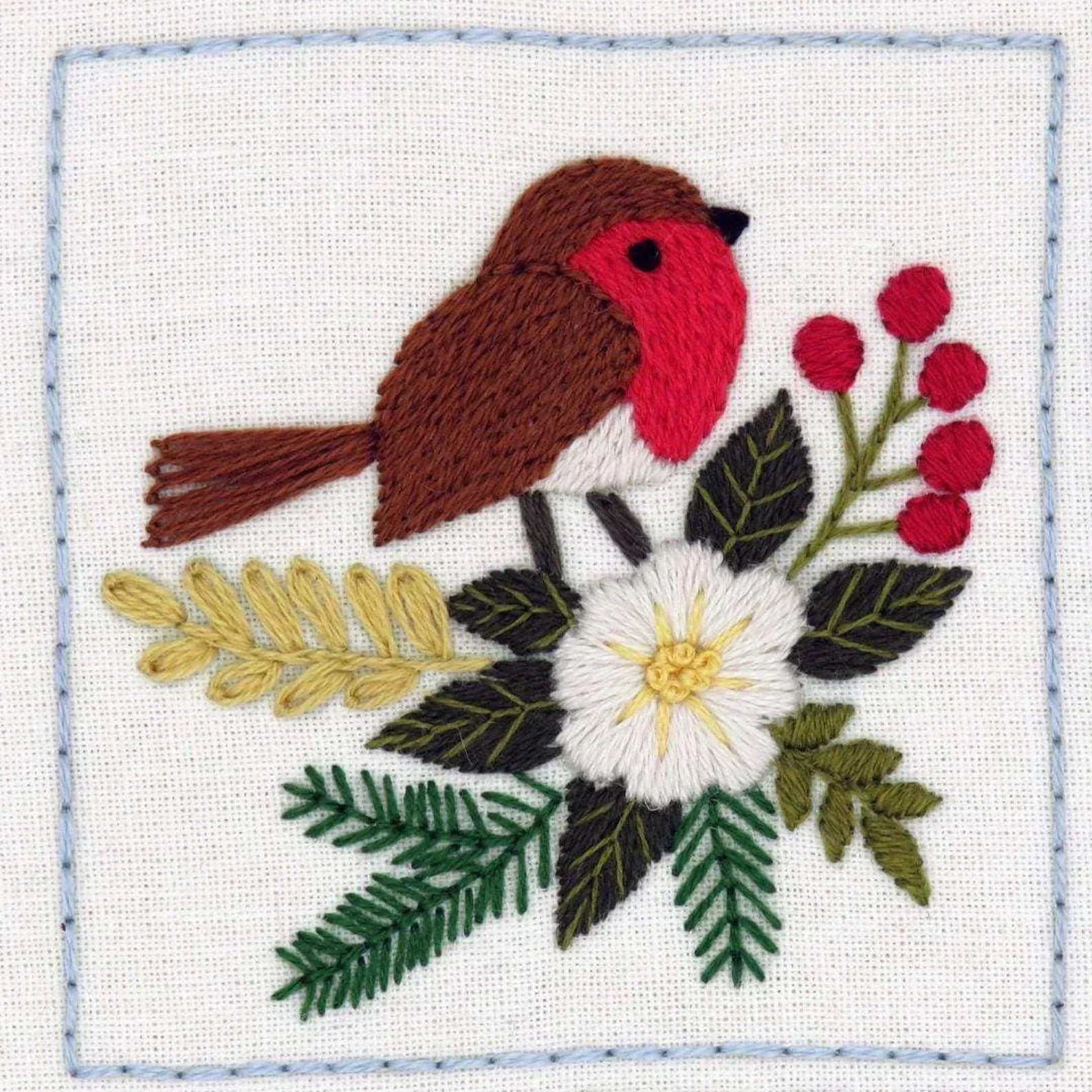 Embroidered patch of a robin with flowers and berries on a white background