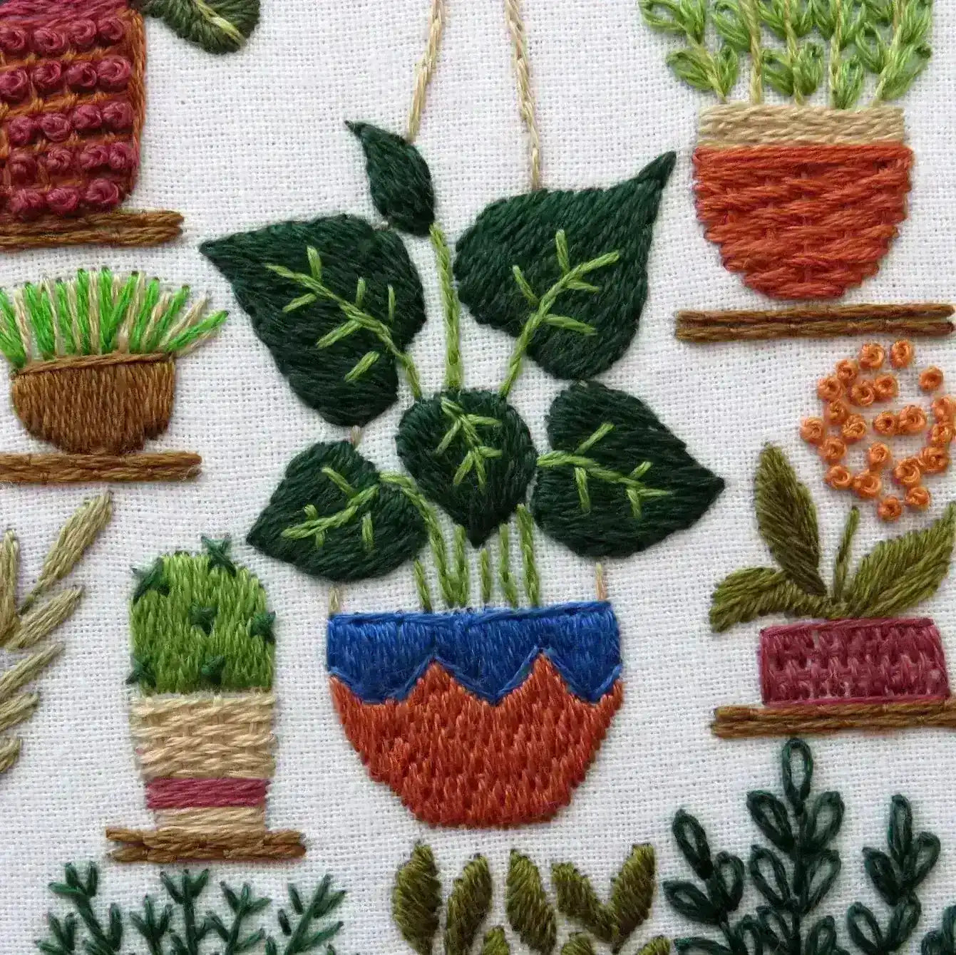 Embroidered pattern of potted plants on a white background