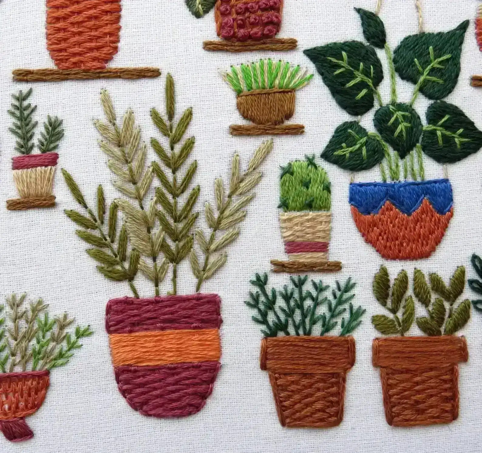 Embroidered pattern of various potted plants on a white background