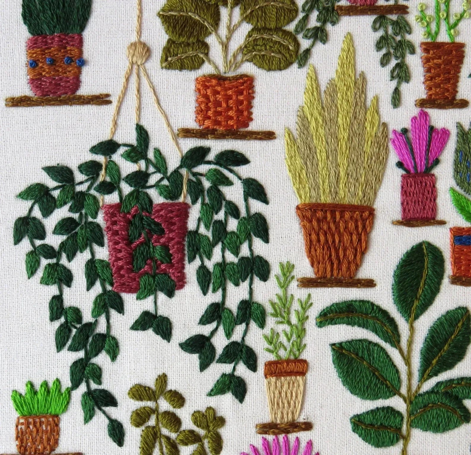 Embroidered pattern of various potted plants on a white background