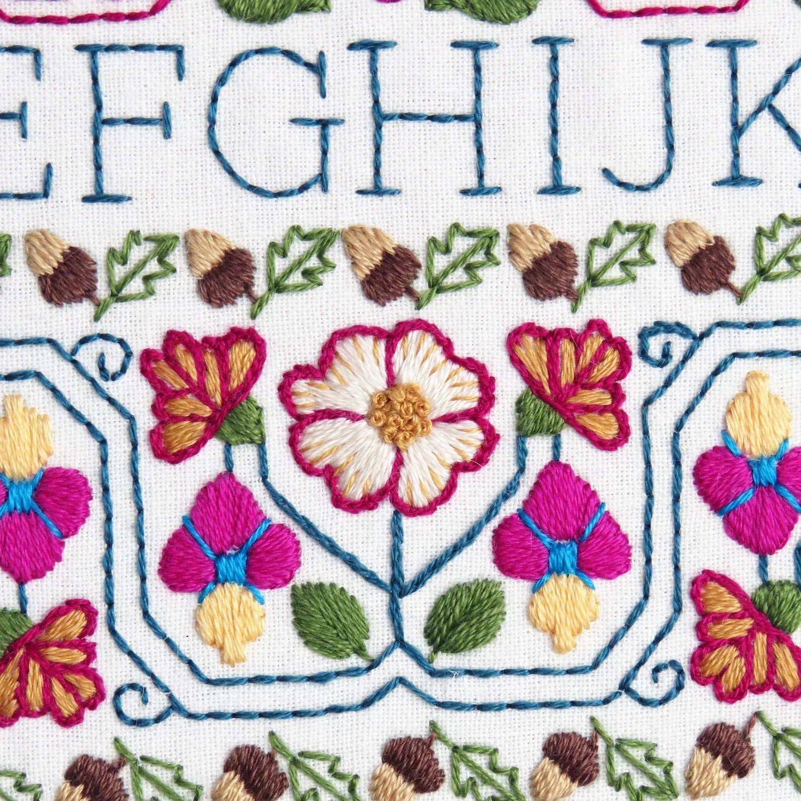 Embroidered pattern with flowers and leaves on a white background