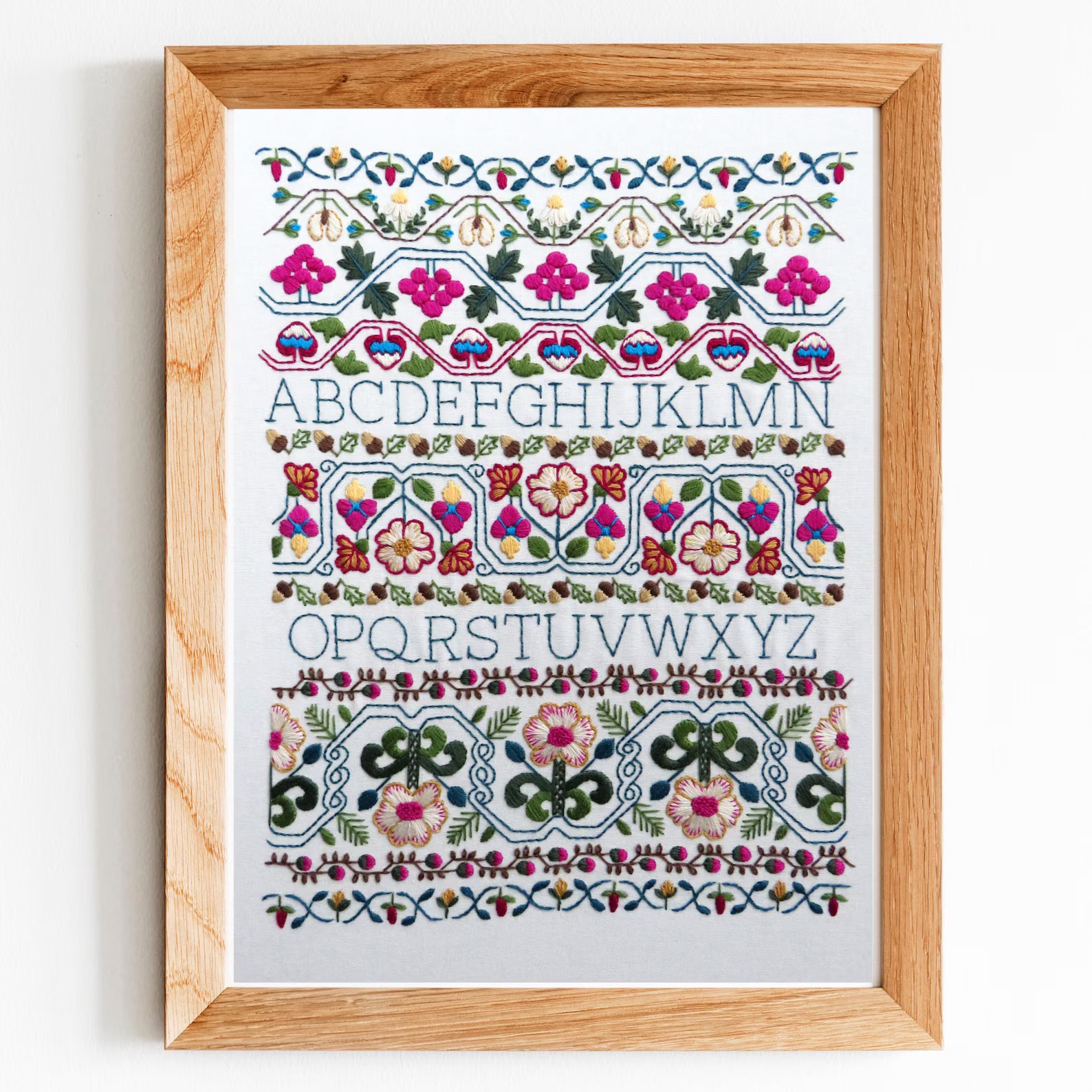 Framed artwork with floral alphabet design on a white background