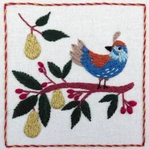 Embroidered design of a bird on a branch with leaves and berries on a white background.