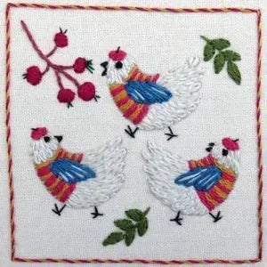 Embroidered design of three chickens wearing scarves with berries and leaves on a white background.