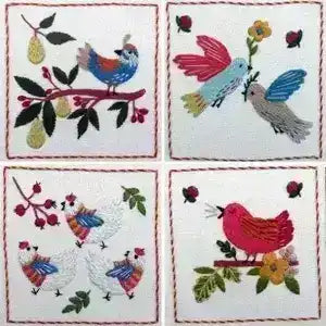Four embroidered coasters with birds and floral designs on a white background