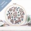 Embroidery hoop with deer and tree pattern on a white background