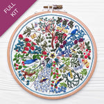 Embroidery hoop with a colorful floral and bird design on a white background