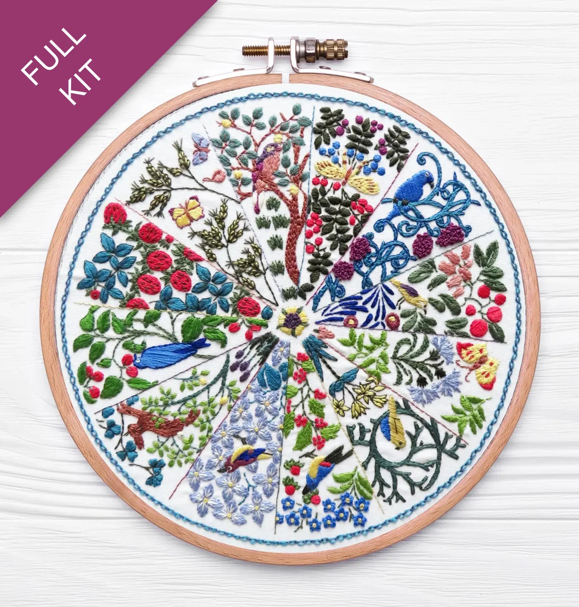 Embroidery hoop with a colorful floral and bird design on a white background